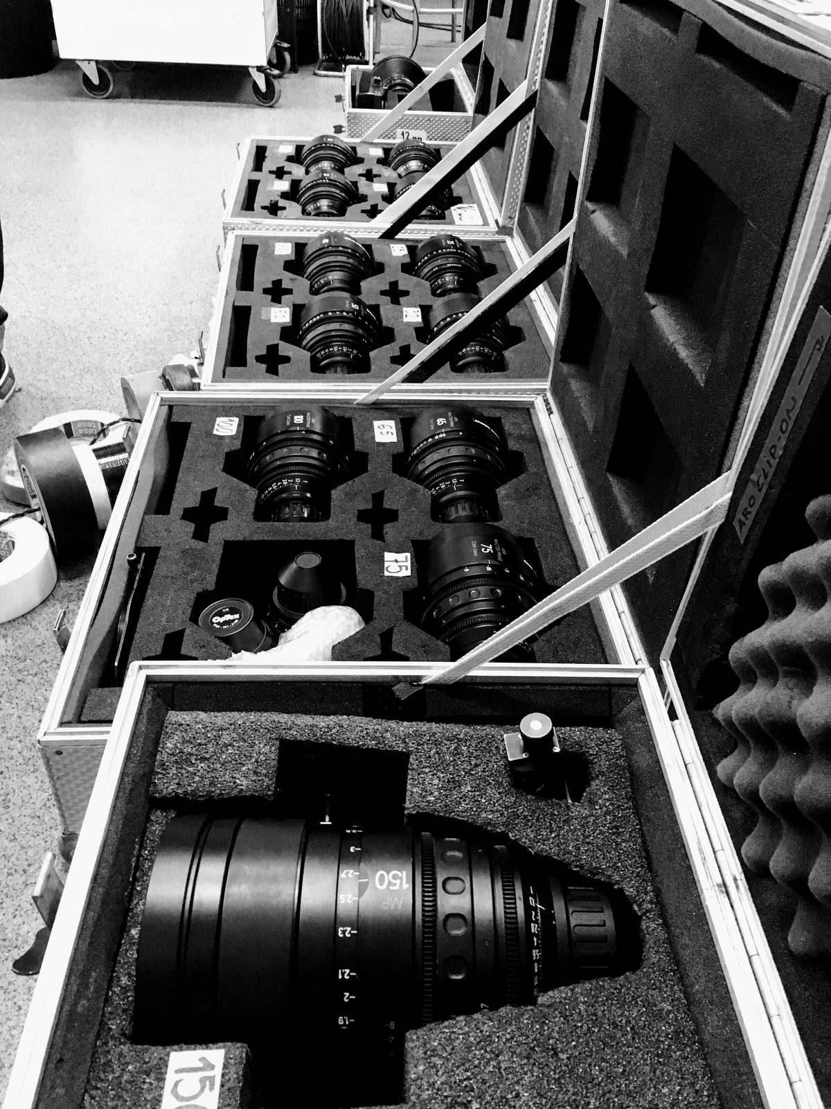 Set of cinema prime lenses laid out in their flight cases during prep